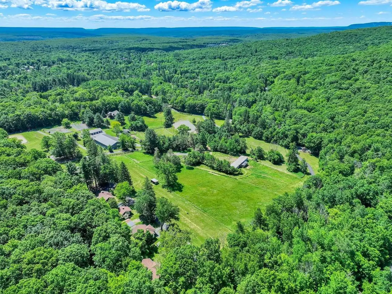 Aerial view of Ik & Lo Resort's houses, lawns and surrounding Pocono forest