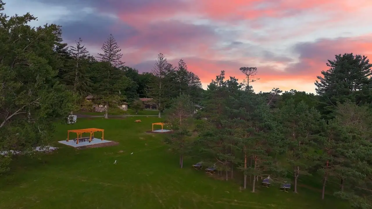 Sunset over the lawns, pergola and houses of Ik & Lo Resort in the Pocono Mountains
