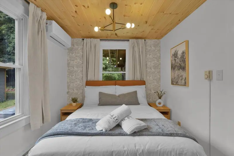 Retreat to a serene queen bedroom with crisp linens, warm wood details and individual climate control.