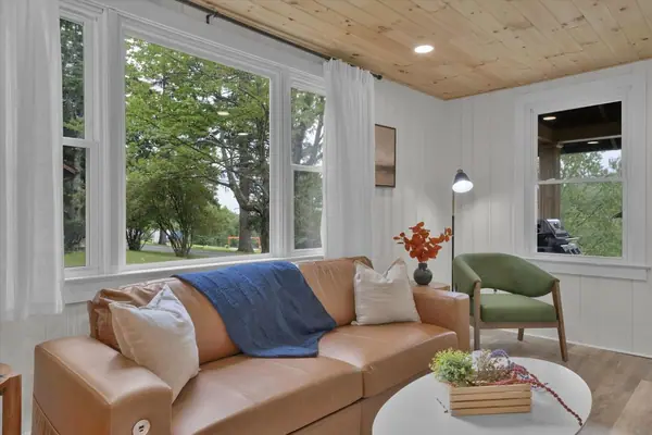 Relax in a light-filled living room surrounded by peaceful views of the property.