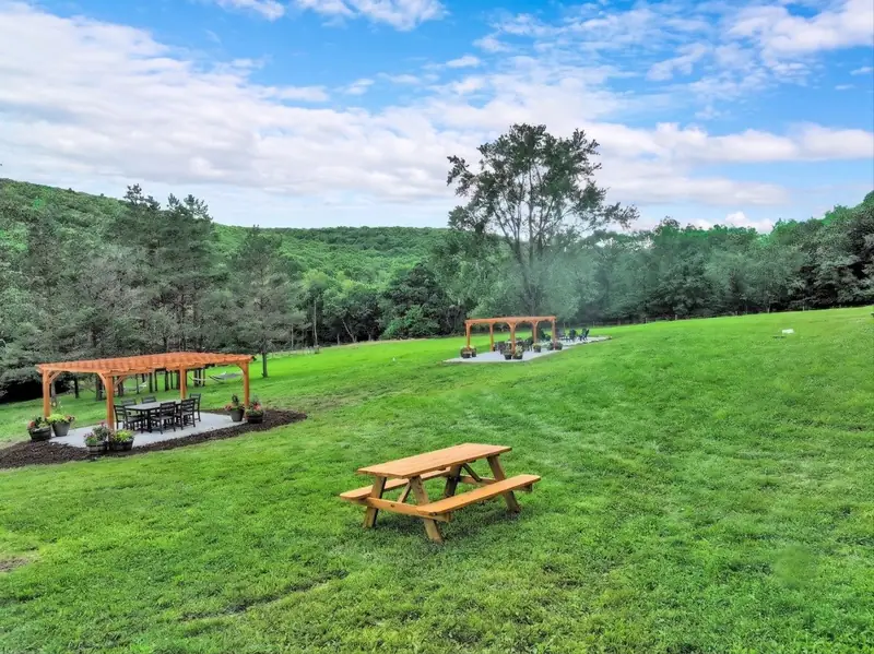 Picnic tables on wide green lawns, with mountains rising on the horizon.