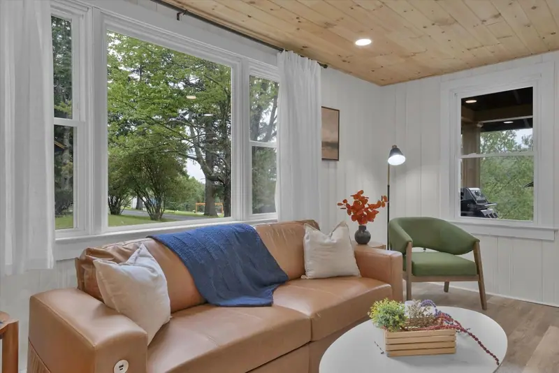 Relax in a light-filled living room surrounded by peaceful views of the property.