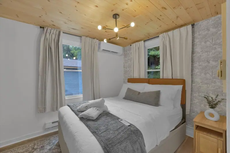 A serene queen bedroom with crisp linens, woodland-inspired details and individual climate control.